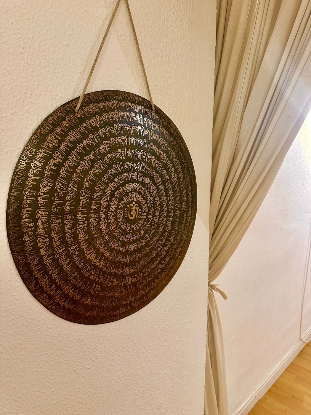 Gong engraved with mantras hanging on the studio wall
